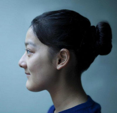 Portrait de profil d'une jeune fille aux cheveux attachés en chignon