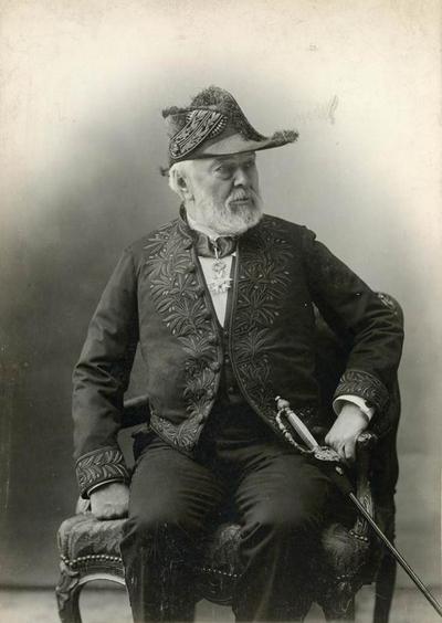 Photographie portrait en noir et blanc d'un vieil homme en costume d'académicien.